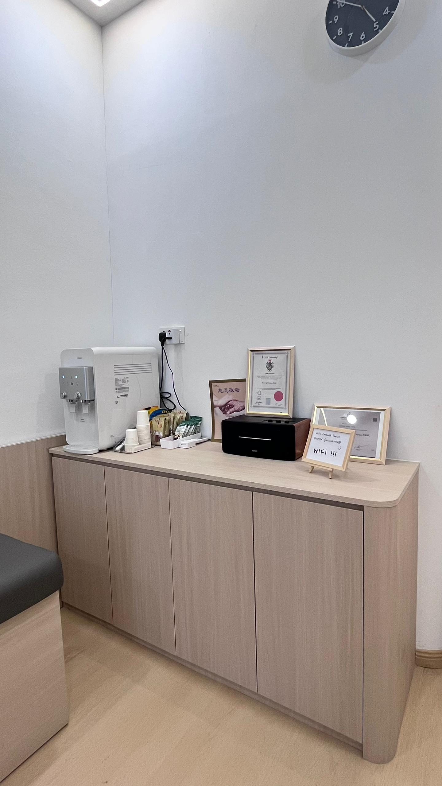 Refreshment corner with water dispenser and clinic certifications at OneHealth Clinic Pontian